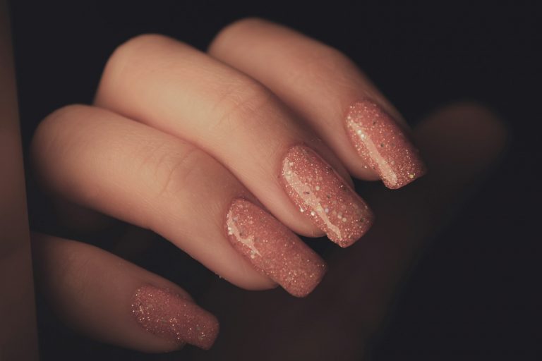 a woman's hand with a pink manicure