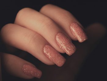 a woman's hand with a pink manicure
