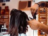 woman in white shirt holding hair blower