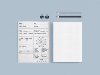 a white paper, pencil, and a piece of paper on a blue surface